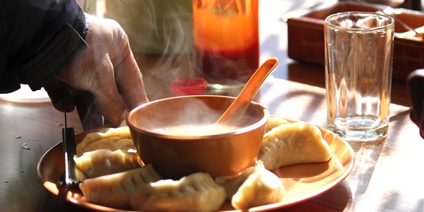 Steaming hot momos served on a plate, showcasing delicious dumplings in Ladakh.
