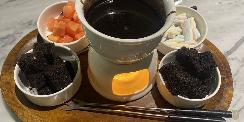 A chocolate fondue served in a white bowl at a restaurant in Maharashtra near Udgir Fort.