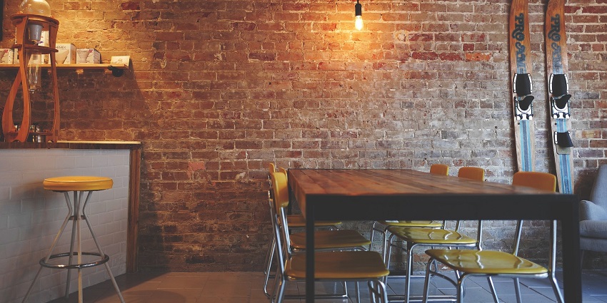 Cosy seating area with stylish chairs against a rustic brick wall backdrop