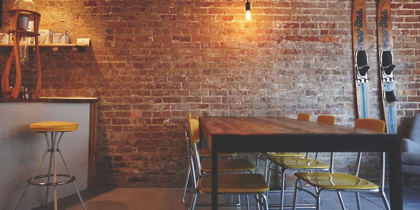 Cosy seating area with chairs against a rustic brick wall backdrop in an elegant setting.