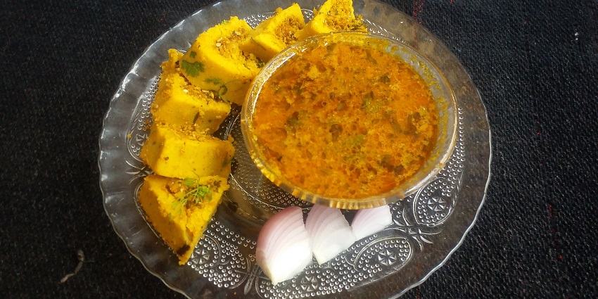A bowl of traditional Maharashtrian Masswadi Rassa, a spicy curry with herbs.