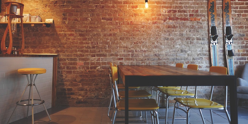 Cosy seating area with stylish chairs against a rustic brick wall backdrop.
