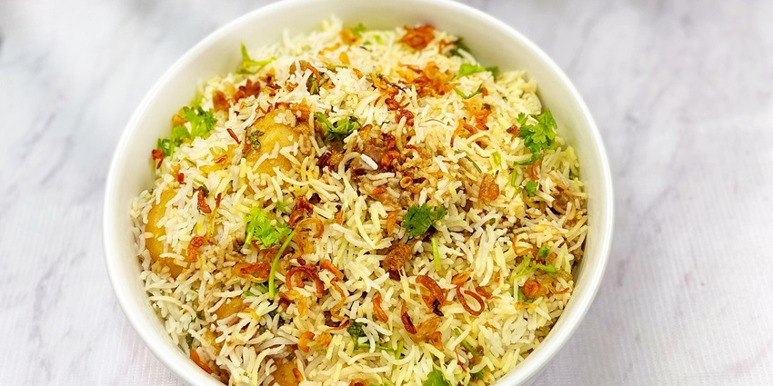 Image of delicious biryani served in a white bowl, showcasing a variety of delicious dishes