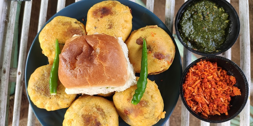 A beautifully arranged bowl of Vada Pavne, showcasing colourful ingredients and elegant presentation