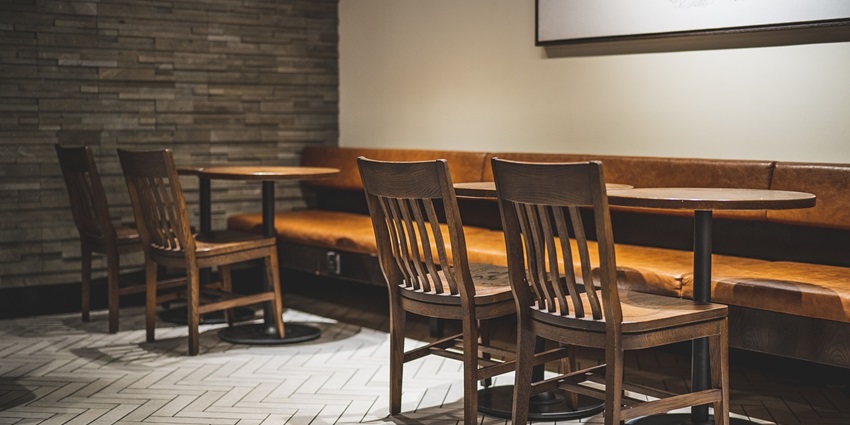 A modern cafe interior featuring chic furniture and warm lighting, creating a cozy ambiance
