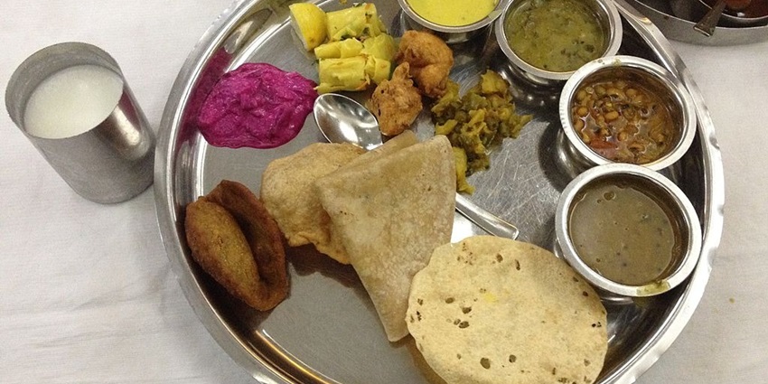 A traditional Maharashtrian thali featuring various dishes served on a round platter