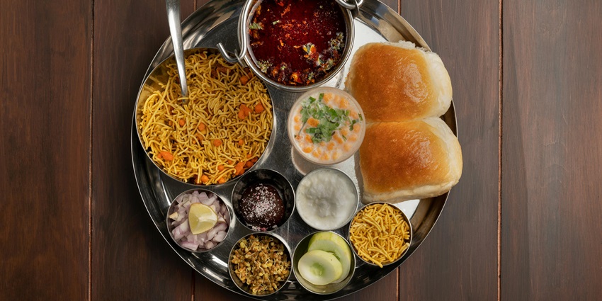 A traditional Maharashtrian thali with various dishes served on a metal plate in Maharashtra