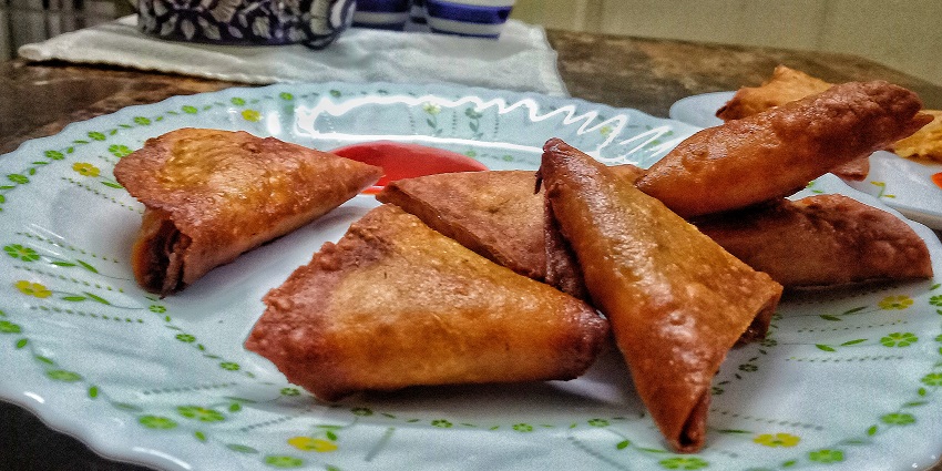 A plate full of tasty coimbatore samosas on display.