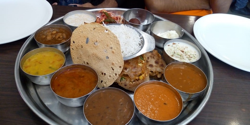 Variety of dishes arranged on a large plate at a restaurant near Pitalkhora Caves.