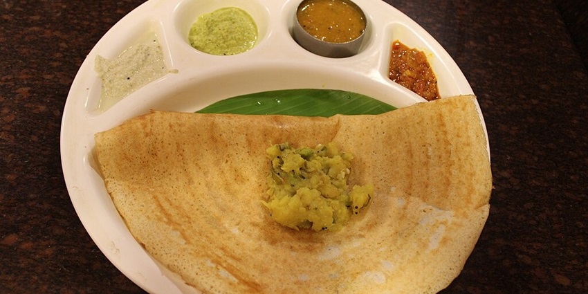 A plate of crispy masala dosa, served with chutneys and sambar