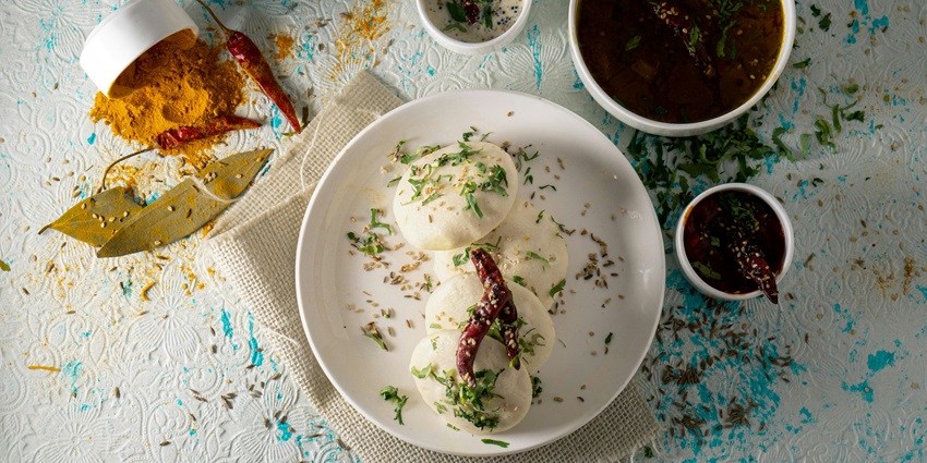 Tasty Indian dishes served with spices and herbs, presented in traditional bowls.