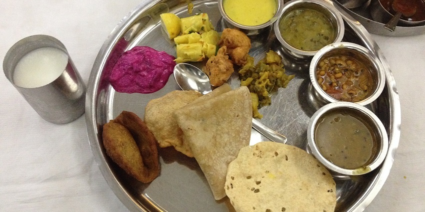 A colourful Maharashtrian thali served on a plate at a traditional restaurant.