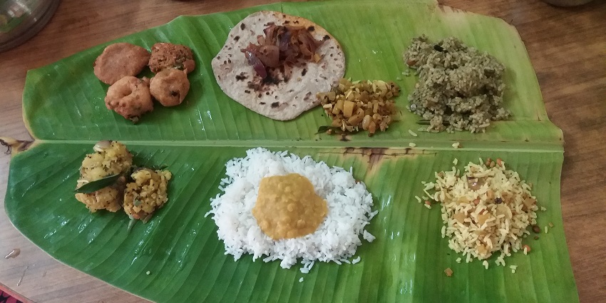 A vibrant spread of traditional South Indian dishes on a banana leaf.
