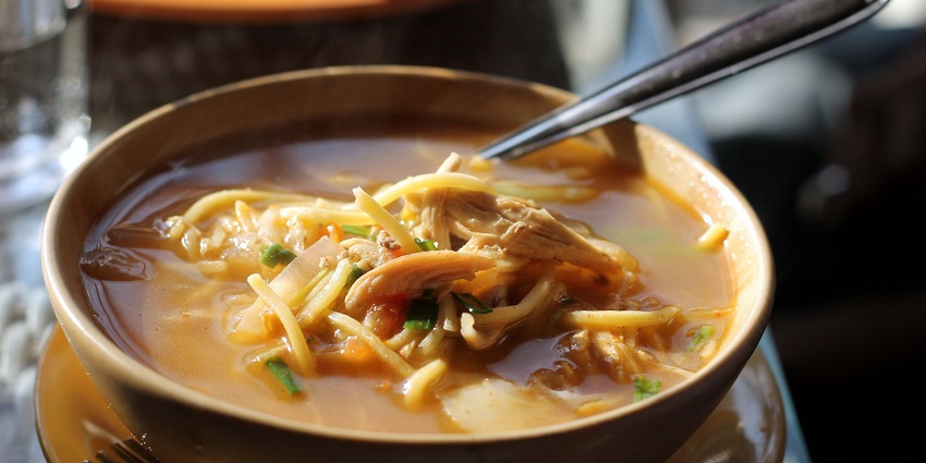  Image of a delectable bowl of Thukpa served in a restaurants soup and non veg on toppings
