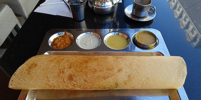 Delicious dosas served with a variety of colourful chutneys on the side