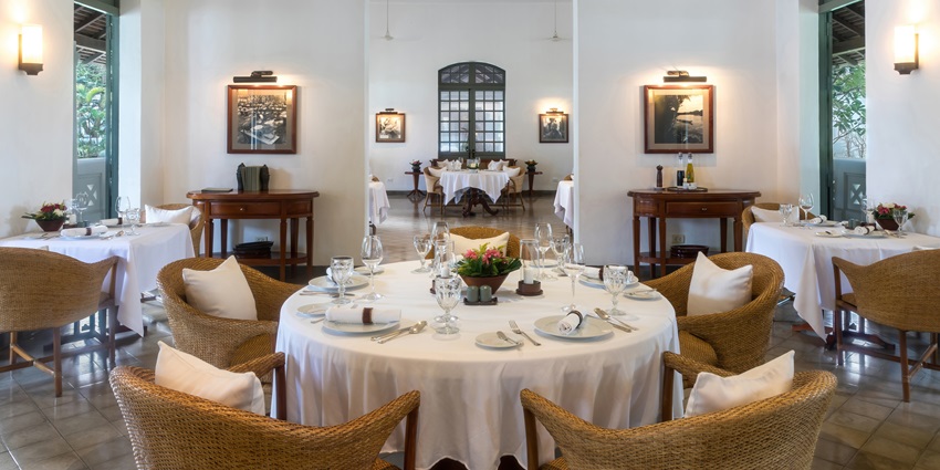 The inside of a luxurious restaurant with properly set table and cutlery ready to serve the costumers.