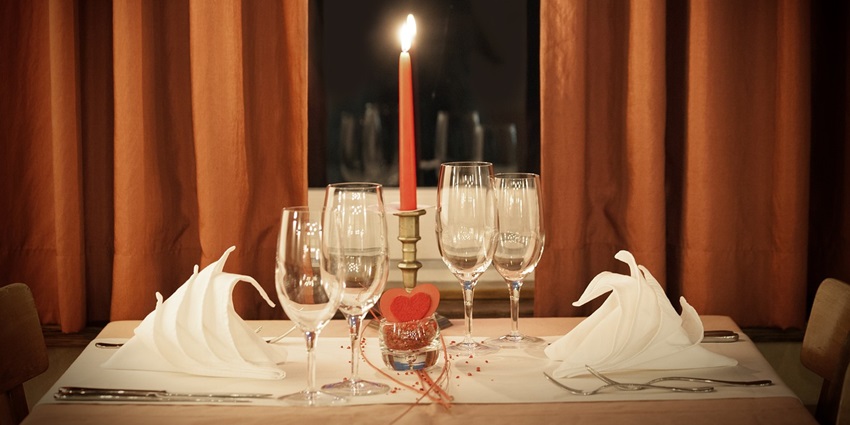 Elegant dinner table setup featuring romantic decorations and candlelight ambience