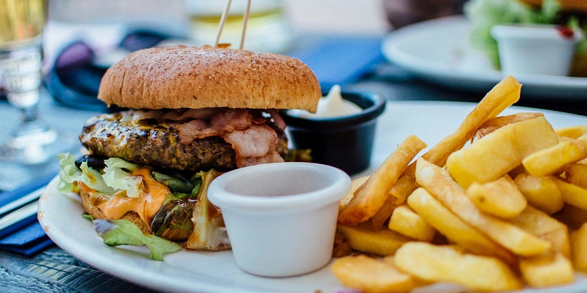 Snapshot of the mouth-watering fries and the delicious burger on a plate in a restaurant