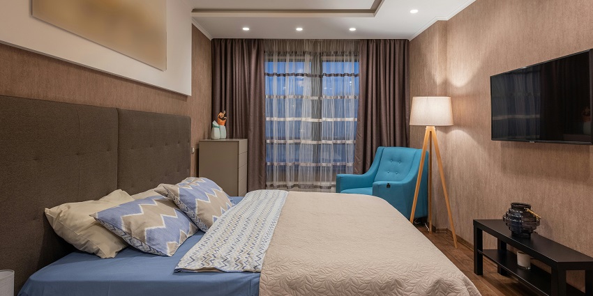 A cosy hotel room featuring a large bed, modern decor, and soft lighting.