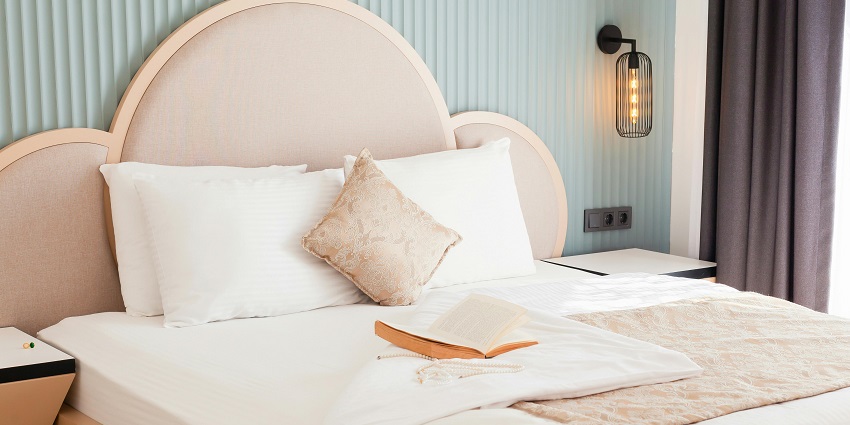Cozy hotel bed adorned with plush pillows and an inviting book for relaxation!