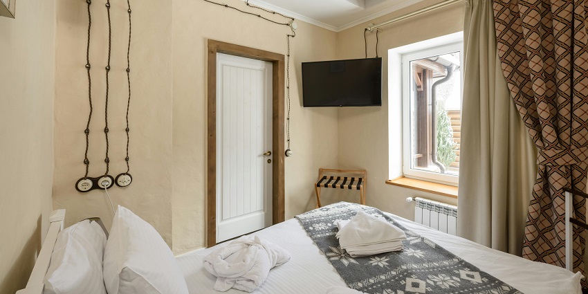 Charming bedroom interior featuring a cosy bed, soft linens, and warm, inviting decor.