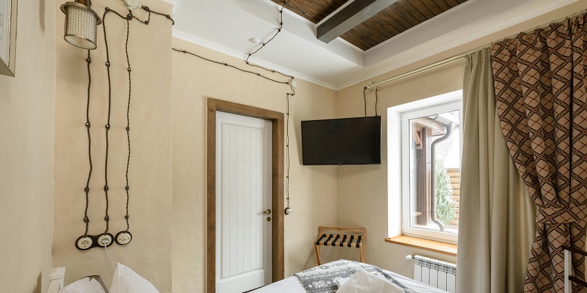 Charming bedroom interior featuring a cosy bed, soft linens, and warm, inviting decor.