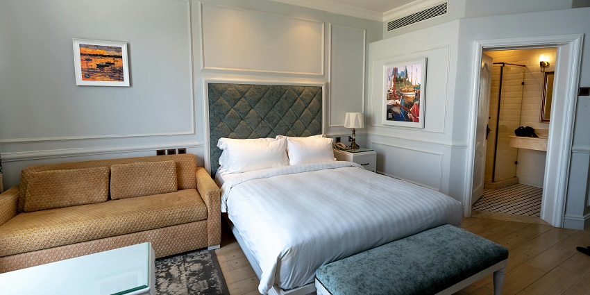 A cosy hotel room featuring a comfortable bed, seating area and an elegant decor.