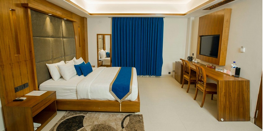 A well-lit hotel room featuring a large bed, and modern decor, ideal for a comfortable stay.