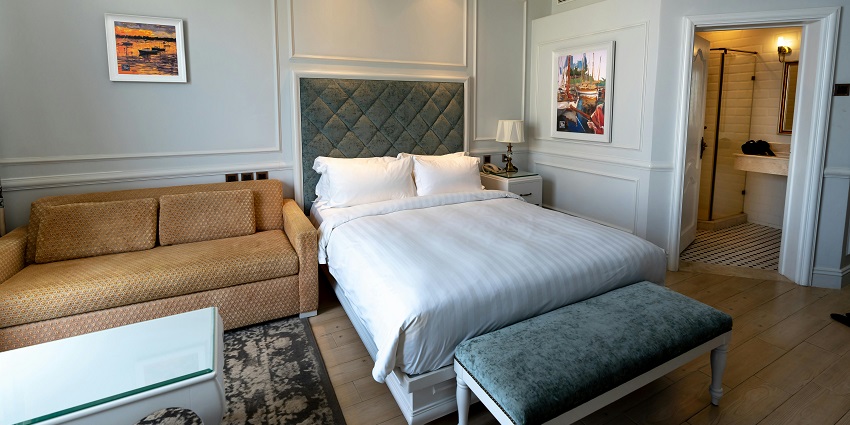 An image of a cosy hotel room featuring a comfortable bed and elegant decor.