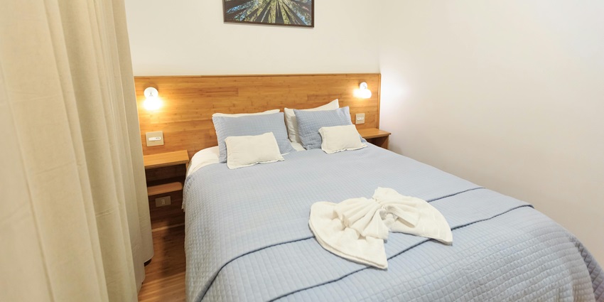 An image of a hotel room featuring a bed, elegant curtains, and aesthetic decor.