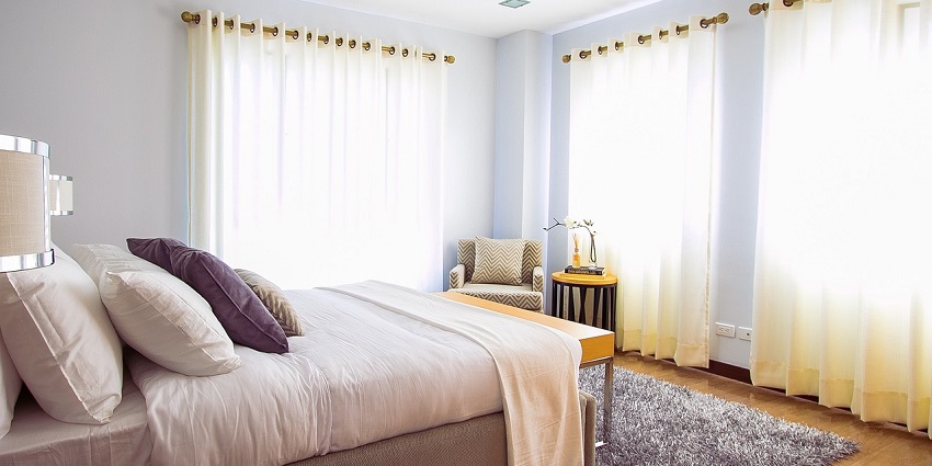 A hotel room with elegant curtains and a serene indoor setting, perfect for relaxation.