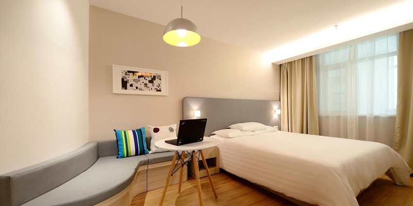 Stylish hotel bedroom with a comfortable workspace, perfect for relaxation and productivity
