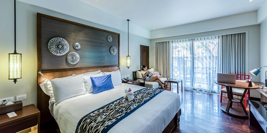 A cosy bedroom interior with modern decor, a neatly made bed, and soft lighting.