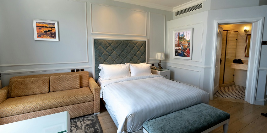 An image of a cosy hotel room featuring a comfortable bed and elegant decor for visitors.