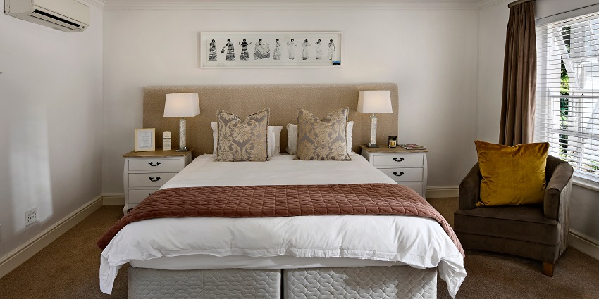 A cosy bedroom with soft pillows neatly arranged on a bed, creating a peaceful atmosphere