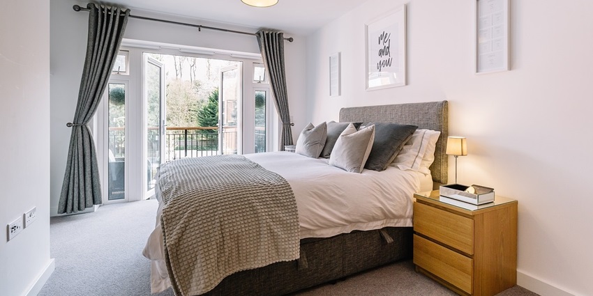A view of a bedroom with interior design featuring a comfortable bed and elegant decor.