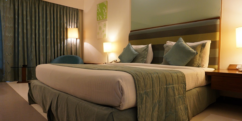 Modern hotel room with a cozy bed, stylish decor, and warm ambient lighting