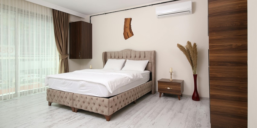 Image of hotel room with clean room and sheets, table on the side and dim lights