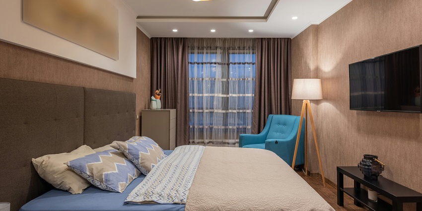 A cosy hotel room featuring a large bed, modern decor, and soft lighting.
