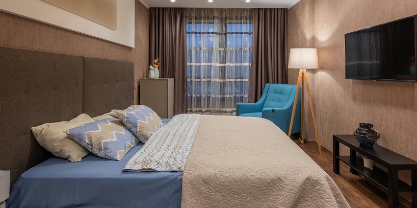 A cosy hotel room featuring a large bed, modern decor, and soft lighting