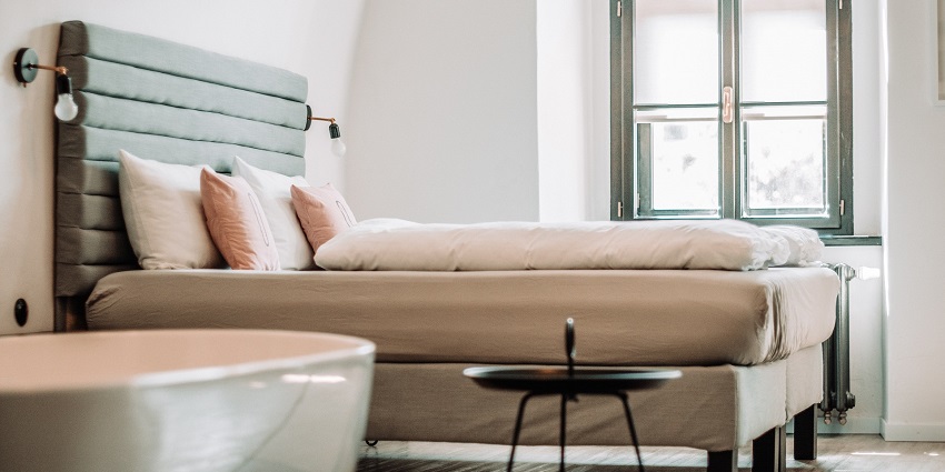 The cozy hotel room features modern decor and comfortable furnishings with cushions.