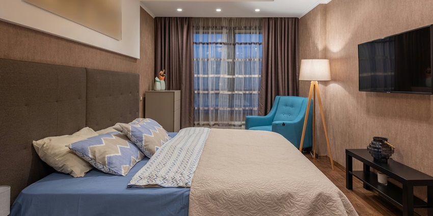 Bedroom with a large bed, and stylish accent chair, comfortable rooms for visitors.