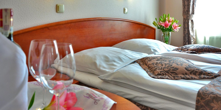 A view of a hotel room with wine glass on a wooden table, a serene ambience near Chanda Fort.