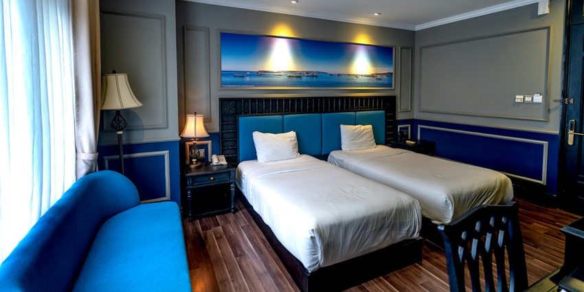 Hotel room with blue furniture and white bed linen at a stylish accommodation.