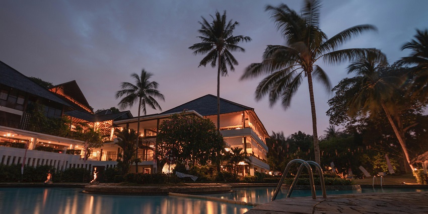 A mesmerising view of a hotel in Goa with dim lights and a swimming pool at night.