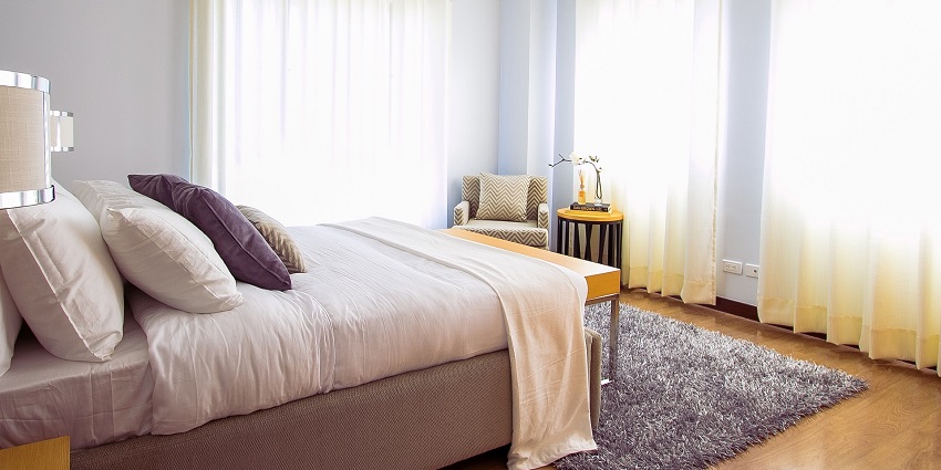 Cosy bedroom featuring a soft carpet beneath a neatly made bed for added comfort.