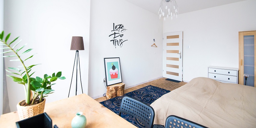 A scenic view of an Elegant bedroom interior featuring a bed with a stylish table beside it.
