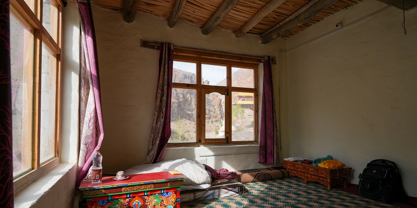 Cozy guest house room in Phuktal, Zanskar, with traditional decor and views.