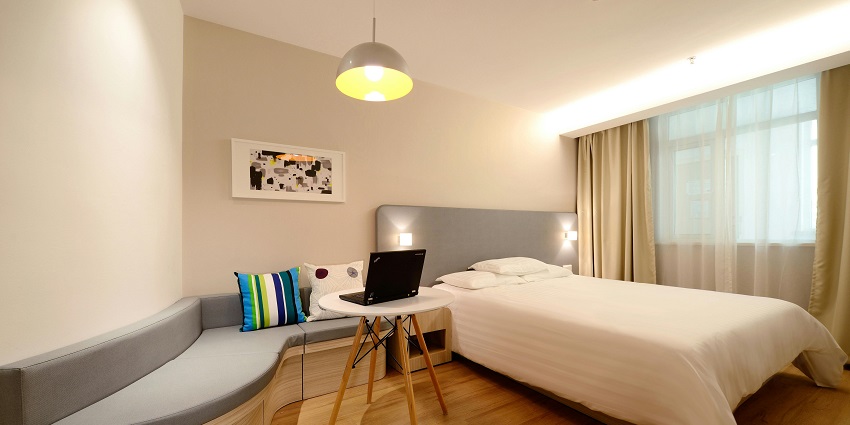 Spacious hotel room featuring a cosy working area, perfect for business travellers.