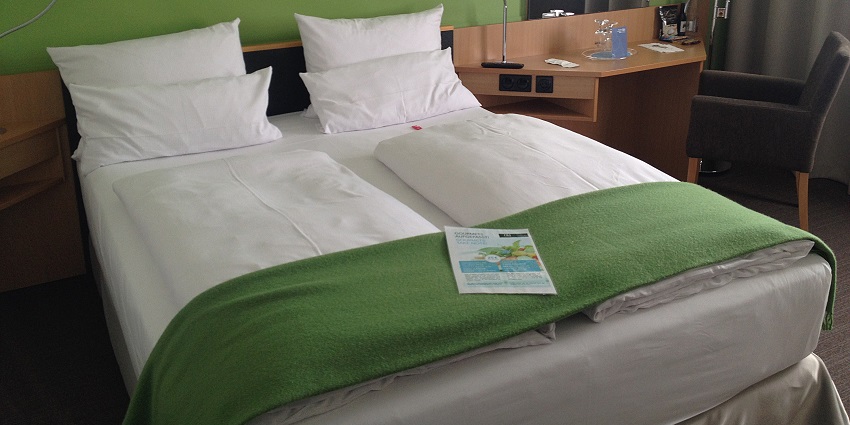 A cosy hotel room featuring warm lighting, comfortable bedding, and decor.